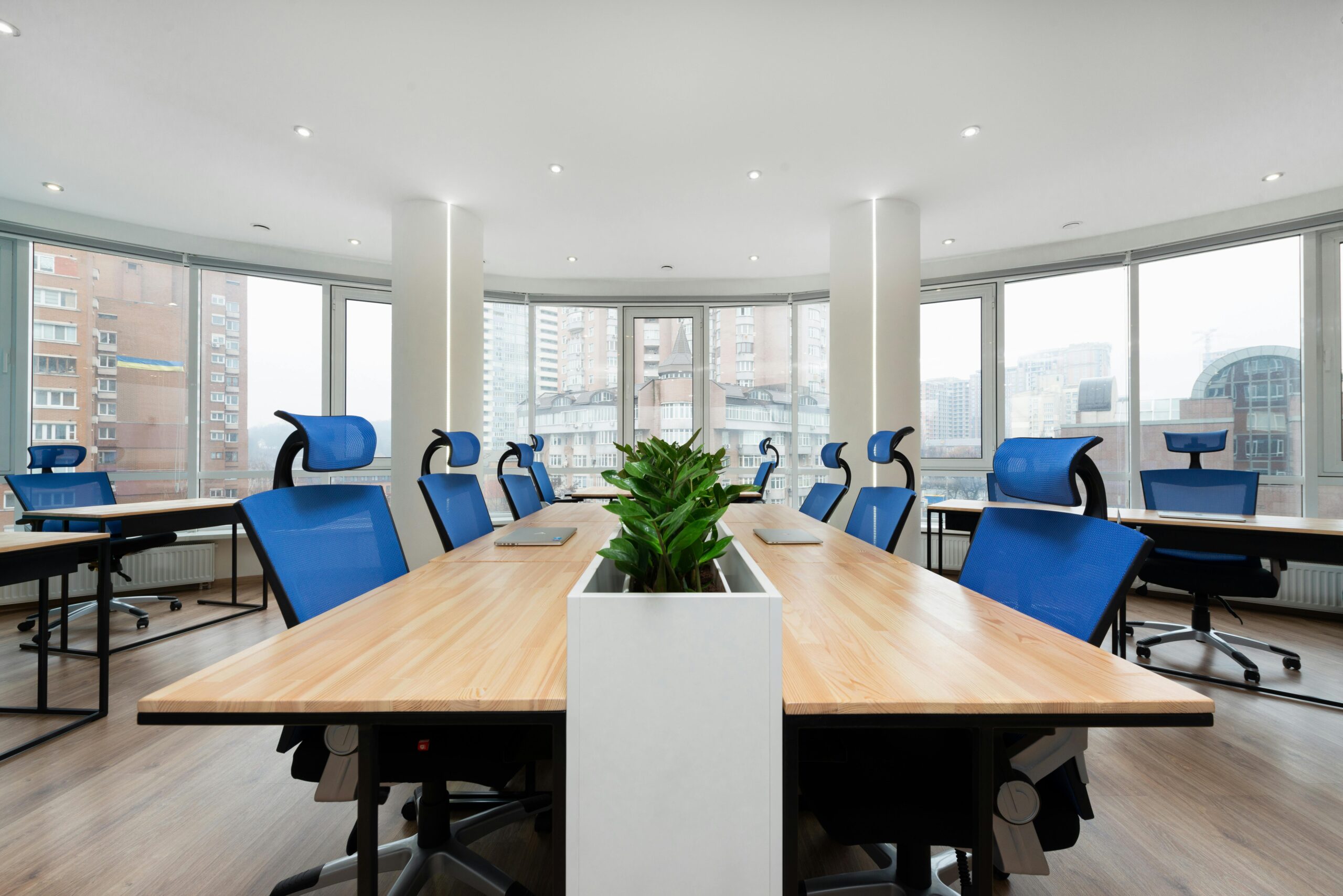 Spacious conference room with blue office chairs and natural light.